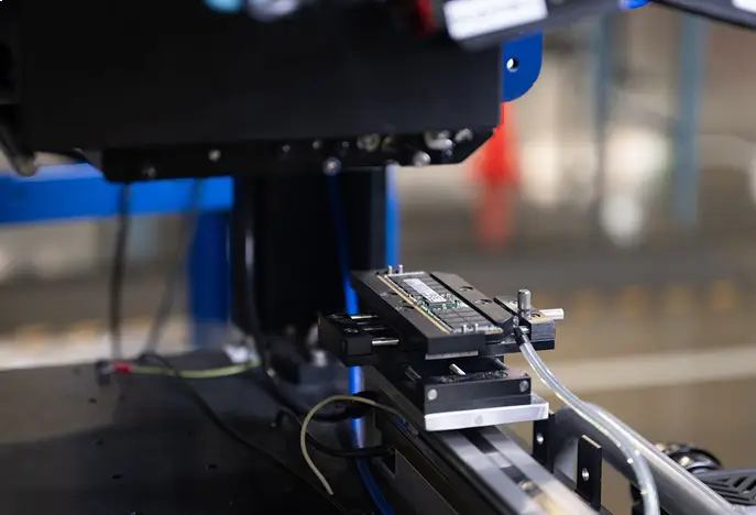 A machine is actively shaping a piece of metal in a workshop setting.