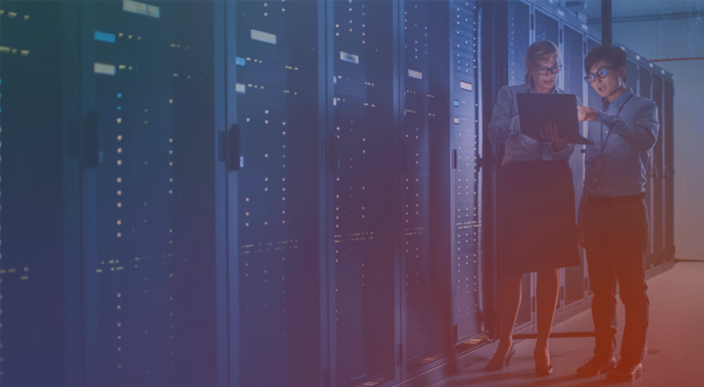 male and female in data center looking at laptop