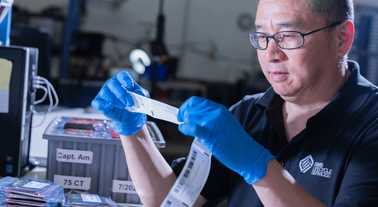 male employee printing out labels for processed IT assets