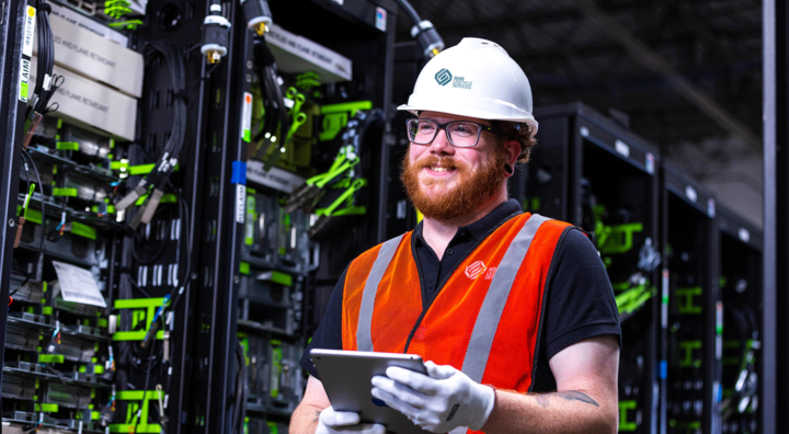 sims lifecycle services employee holding tablet in circular center