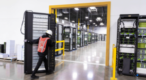 male employee moving server racks in preparation of decommissioning